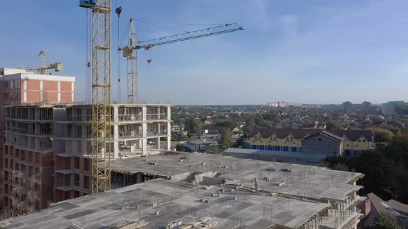 Building crane and monolituc building under construction. Construction site.