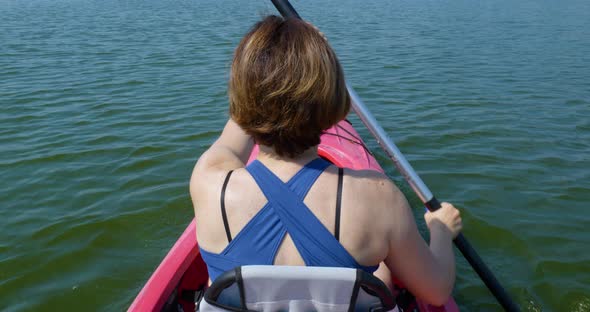 Slow Motion of Woman Swims on a Kayak on a Calm River