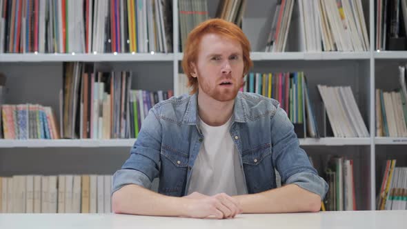 Redhead Man Listening Secret Carefully in Office Library