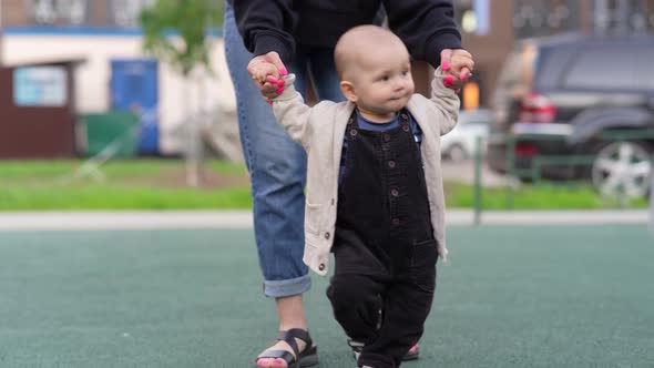 Baby Boy Holding Hands His Mom and Walking Together at the Playground