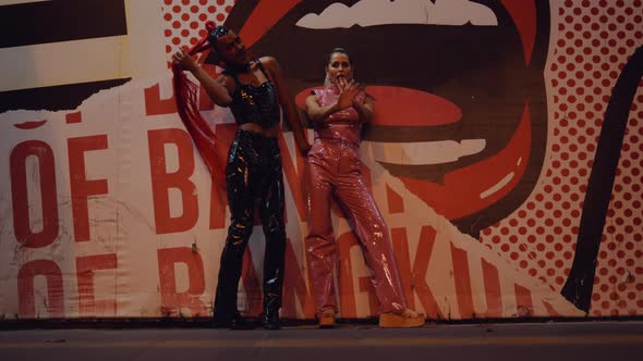 Young Woman And Man In Pvc Clubwear Dancing And Singing By Graffiti