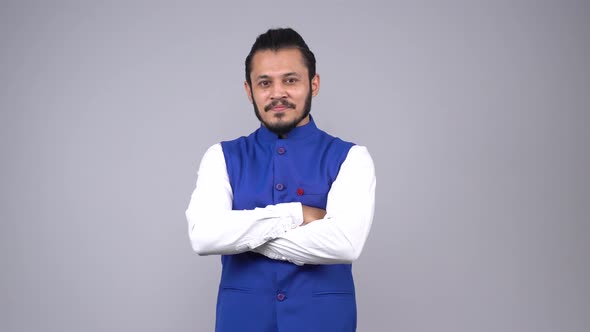 Confident Indian man standing crossed hands