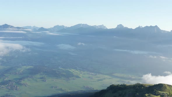 Mist Partially Covering the Fields and Glimpse of Towering Mountains in Austria