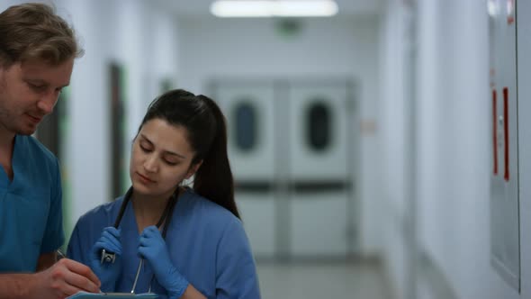 Indian Woman Doctor Consulting Man Surgeon in Hospital Corridor Close Up