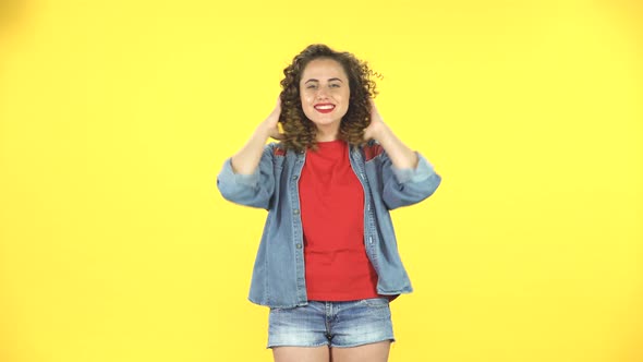 Playful Curly Woman Waving Her Head and Looking at the Camera