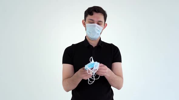 Young Confident Man Wearing Protective Mask Counting Medical Masks.
