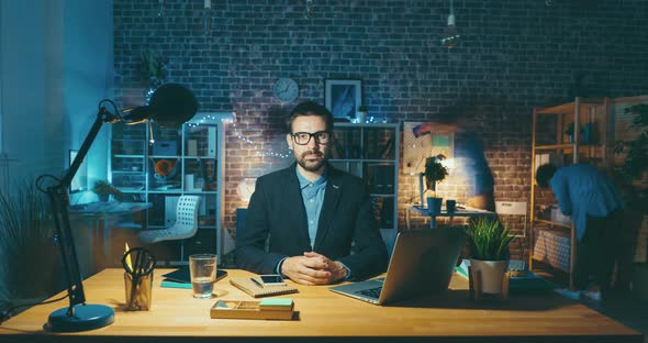 Time Lapse Portrait of Handsome Man Sitting at Desk in Office Looking at Camera