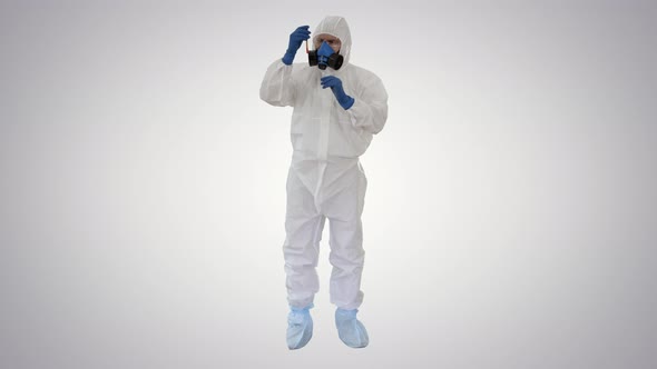 Doctor in Hazmat Suit and Gas Mask Holding Test Tube of Blood on Gradient Background
