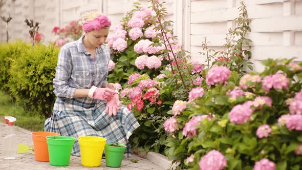 Woman Gardening - Happy Female Gardener Taking Care of Flowers in Backyard.