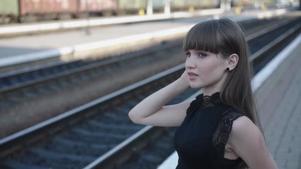 Beautiful Coquette in Blackwhite Dress Poses with Smile at Railway