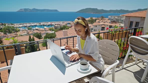 Slow Motion of Beautiful Young Freelancer Woman Working on Laptop Outdoors on Terrace at Hotel