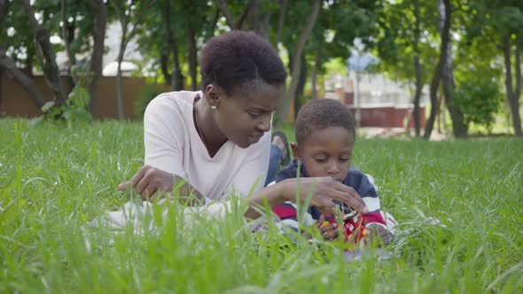 Portrait Adorable Cute African American Pretty Young Woman Lying on the Blanket with Her Little Son