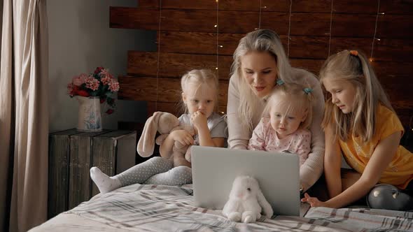 Mother with Kids Looking at Computer Display Inside Room