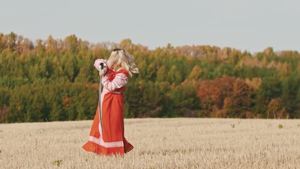 Feisty Woman in Red Dress Training on the Field - Trains with a Sword