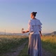 a woman with a glass walks through the field - VideoHive Item for Sale