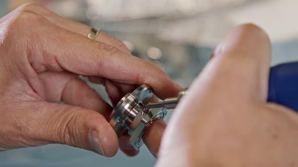 Close up on worker hands during metal part finishing process