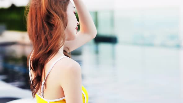 Asian young woman relax in swimming pool at luxury hotel