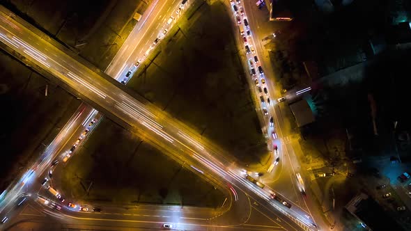 Aerial View of Road Intersection with Fast Moving Heavy Traffic at Night