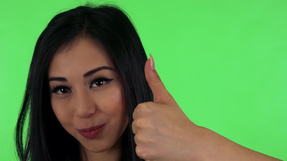 Young Attractive Asian Woman Shows Thumb on Agreement - Green Screen - Closeup