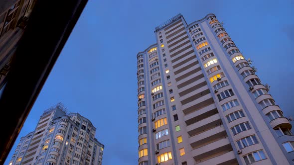 Clouds Are Moving Rapidly Over Modern Apartment Buildings. Bottom View. City Street in the Evening.