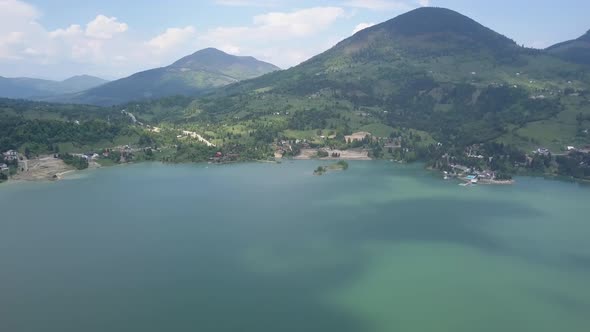 Aerial Panning in the middle of the lake showing the surrounding landscape of valley with woodland a