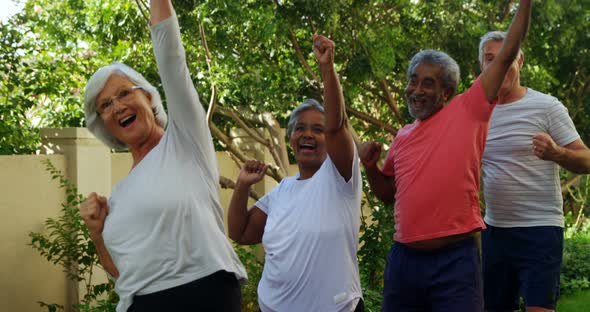 Senior friends doing exercise in garden 4k