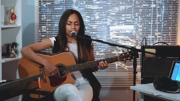 Black Woman Vocalist Recording a Song and Playing Guitar in Home Studio