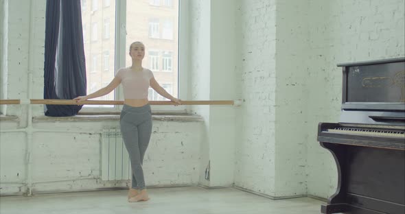 Ballet Dancers Practicing Grand Battement at Barre