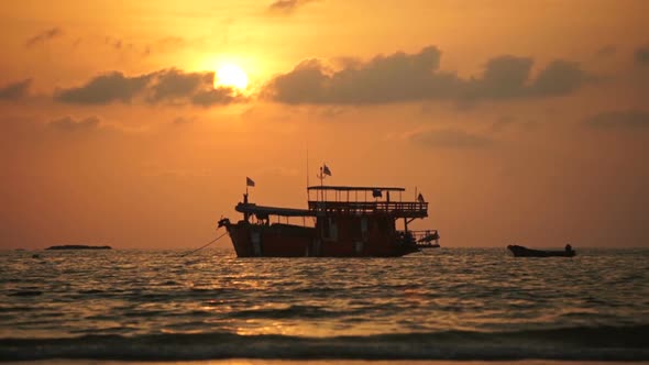 Tourist Boat Rocks on the Waves at Anchor in the Rays of the Sunset