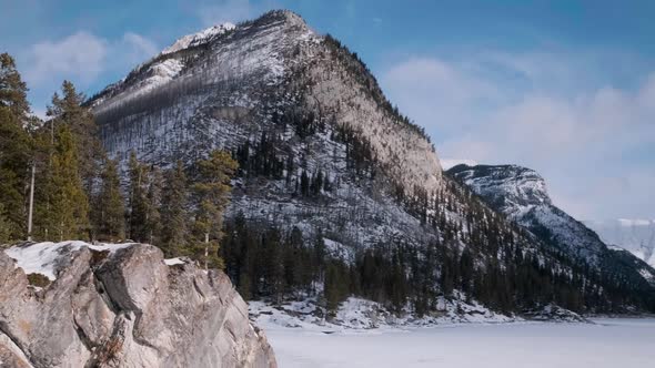 Young Hiking Couple Enjoys the Breathtaking Winter Lookout in Snowy Mountains of Banff National Park