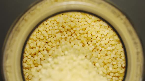 Couscous Grains Pouring Into A Glass Jar