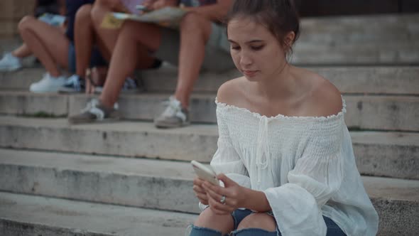 Resting Place of Youth in City Sit on Stair and Use Cell Phones