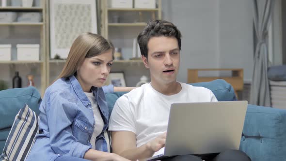 Frustrated Unhappy Young Couple Reacting to Loss on Laptop