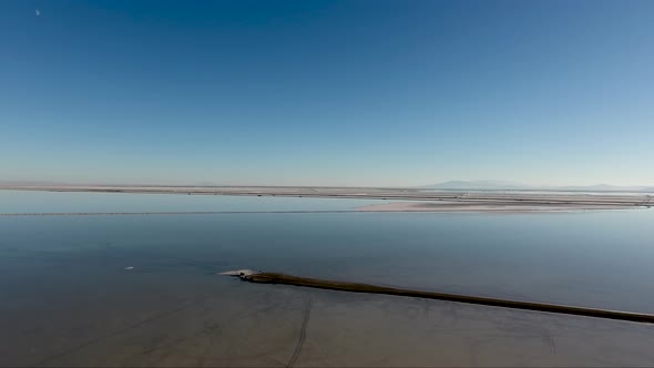 A drone shot flying over the Bonneville Salt Flats shows the Salt Flats causeway and the flooded sal