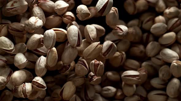 Super Slow Motion Shot of Pistachios Flies After Being Exploded Against Black Background 1000Fps