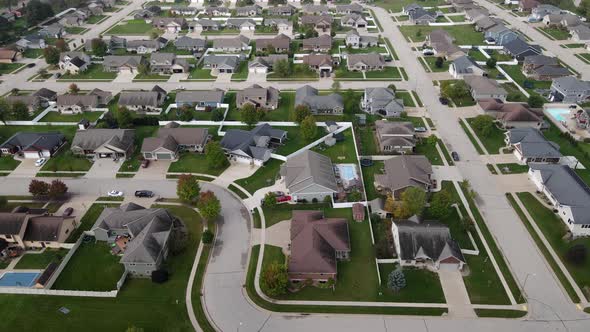 Aerial view of residential neighborhood and park and playground. Wide streets with manicured lawns.