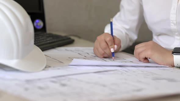 Construction engineer makes notes on paper plans