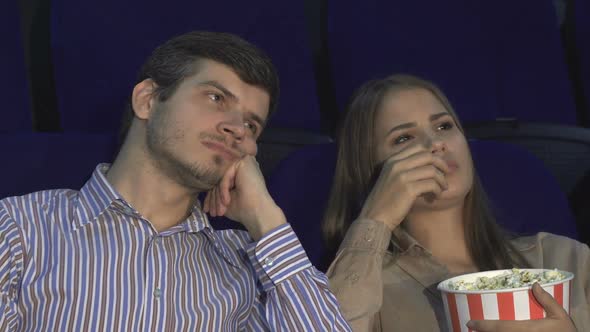 Cute Couple Bored While Watching a Movie at the Cinema