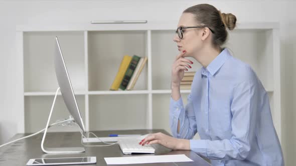 Pensive Young Casual Girl Thinking While Working on Computer