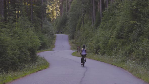 Adventurous Woman Bike Riding on a Trail in Forest