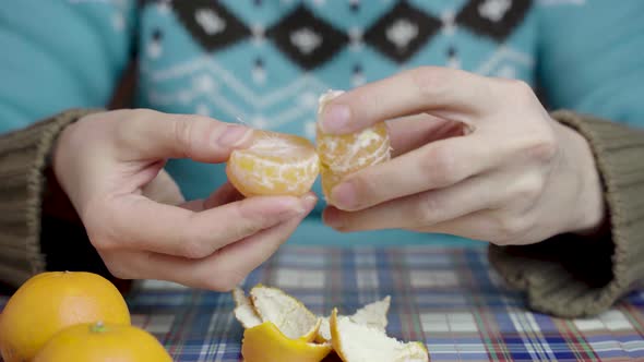 Beautiful female hands peel tangerine, Christmas treats
