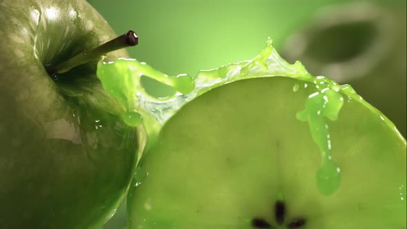 Slow Motion Shot of Green Apple Juice Splashing Through Apple Slices