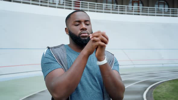 Athlete Warming Arms Before Workout on Track. Man Preparing for Running Outdoors