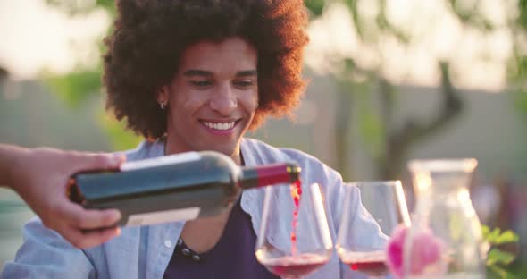 Waiter Open Wine Bottle and Pouring Red Wine in Glass While People, Talking,eating,drinking During