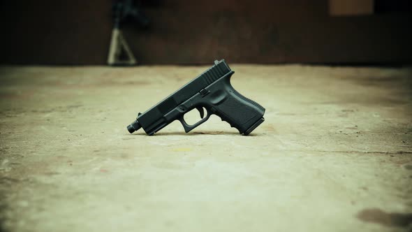 View of a Black Handgun on a Concrete Background