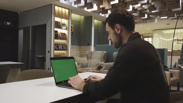 Young focused handsome male businessman working on the laptop