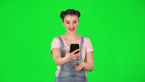 Smiling Girl Talking for Video Chat Using Mobile Phone and Rejoice on Green Screen