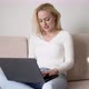 Glad Female Using Laptop on Sofa - VideoHive Item for Sale