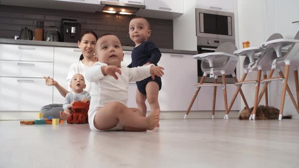 Asian Mom Singing and Encouraging Toddler Triplets to Dance