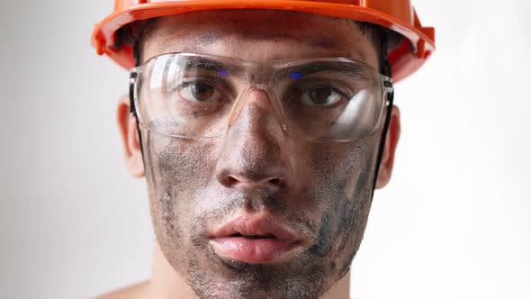 Portrait Dirty Tired Male Builder in Work Helmet and Glasses Looks Camera